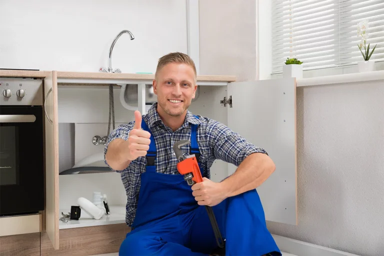 Emergency plumber fixing burst pipe under kitchen sink in Cape Town